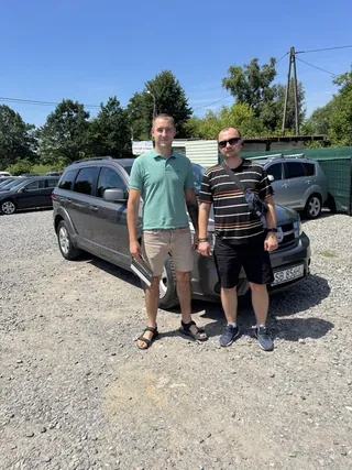 Troje klientów przy ciemnym kombi